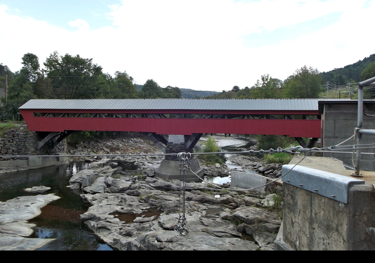 Taftsville Covered Bridge spans the Ottauquechee River in the Taftville village of Woodstock, Vermont .
